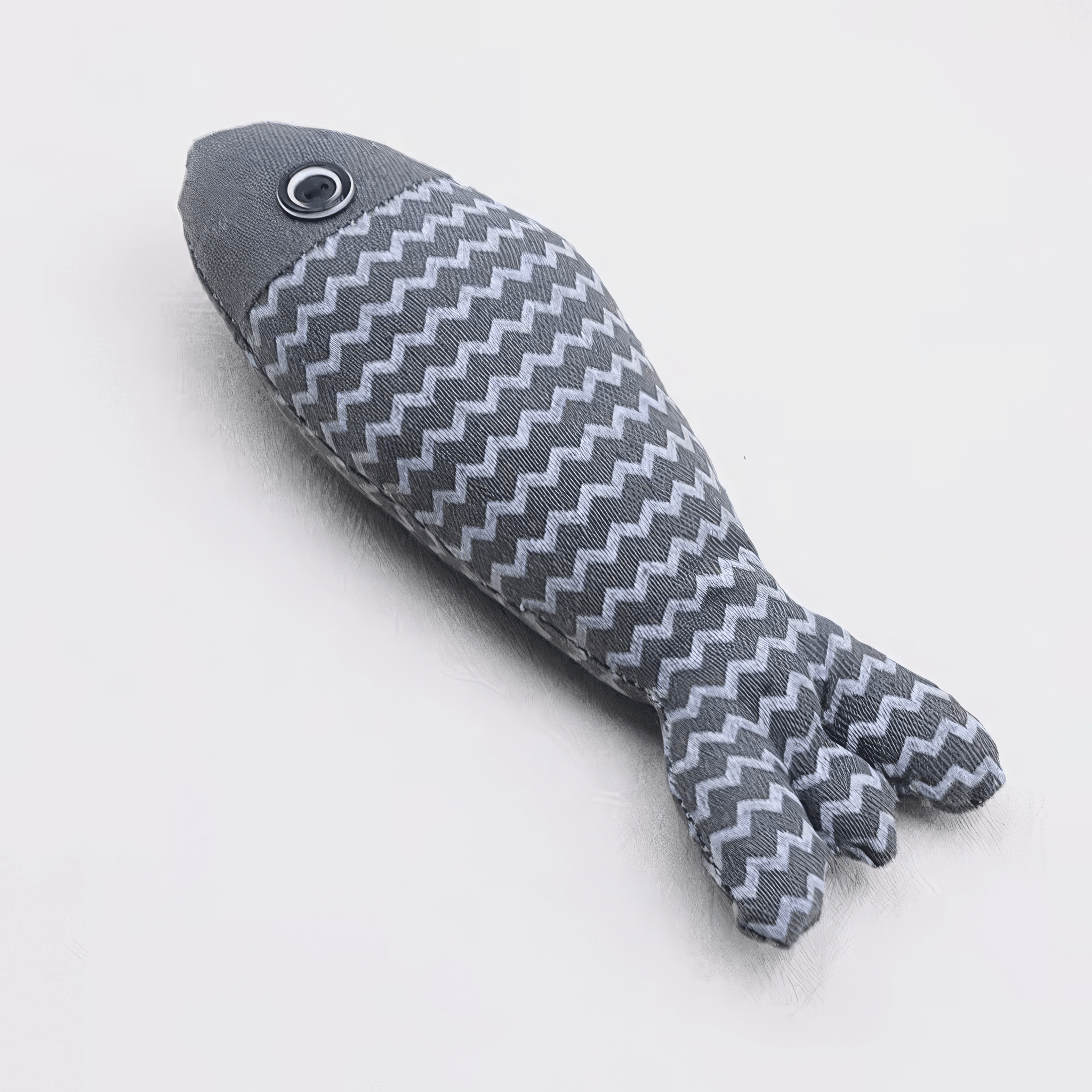 Grey catnip fish toy with white zigzag pattern on a white background