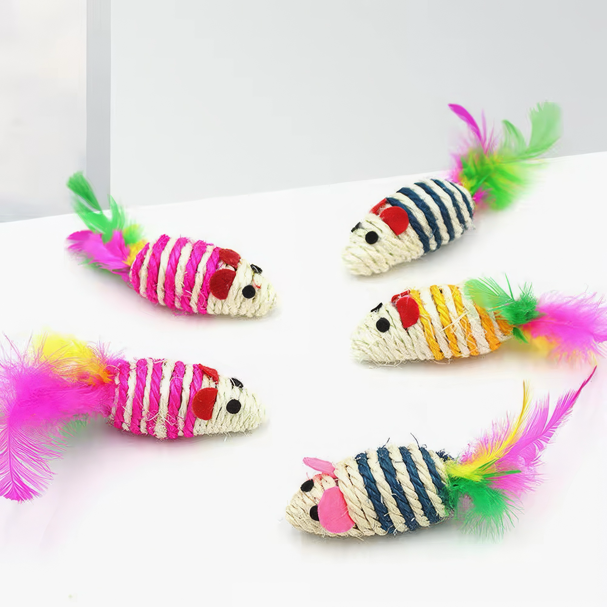 Colorful cat toys shaped like striped mice with feathers on a white background